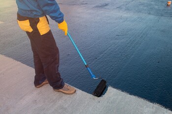Roofer applying roof coating in Sellersville, PA